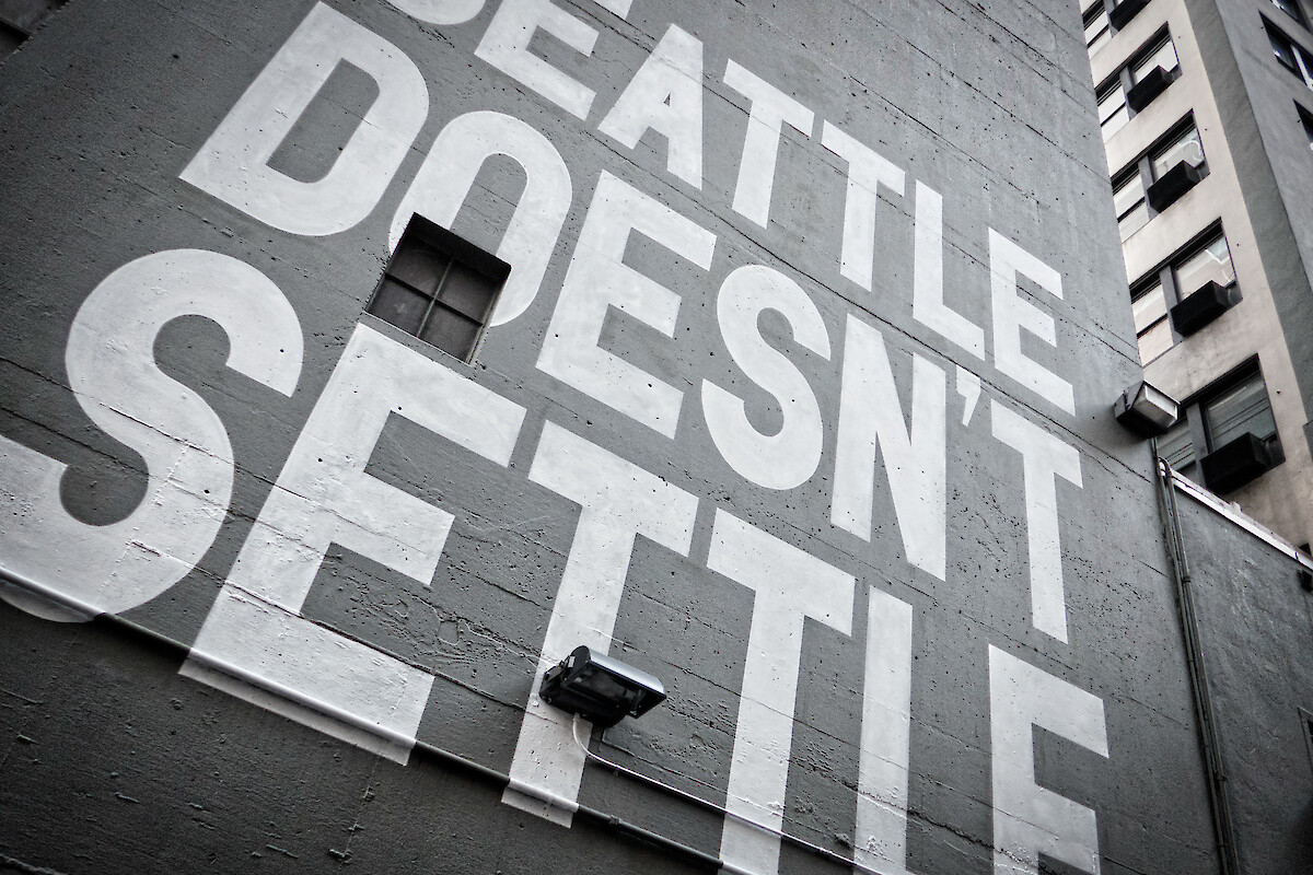 A mural on a building features the bold text