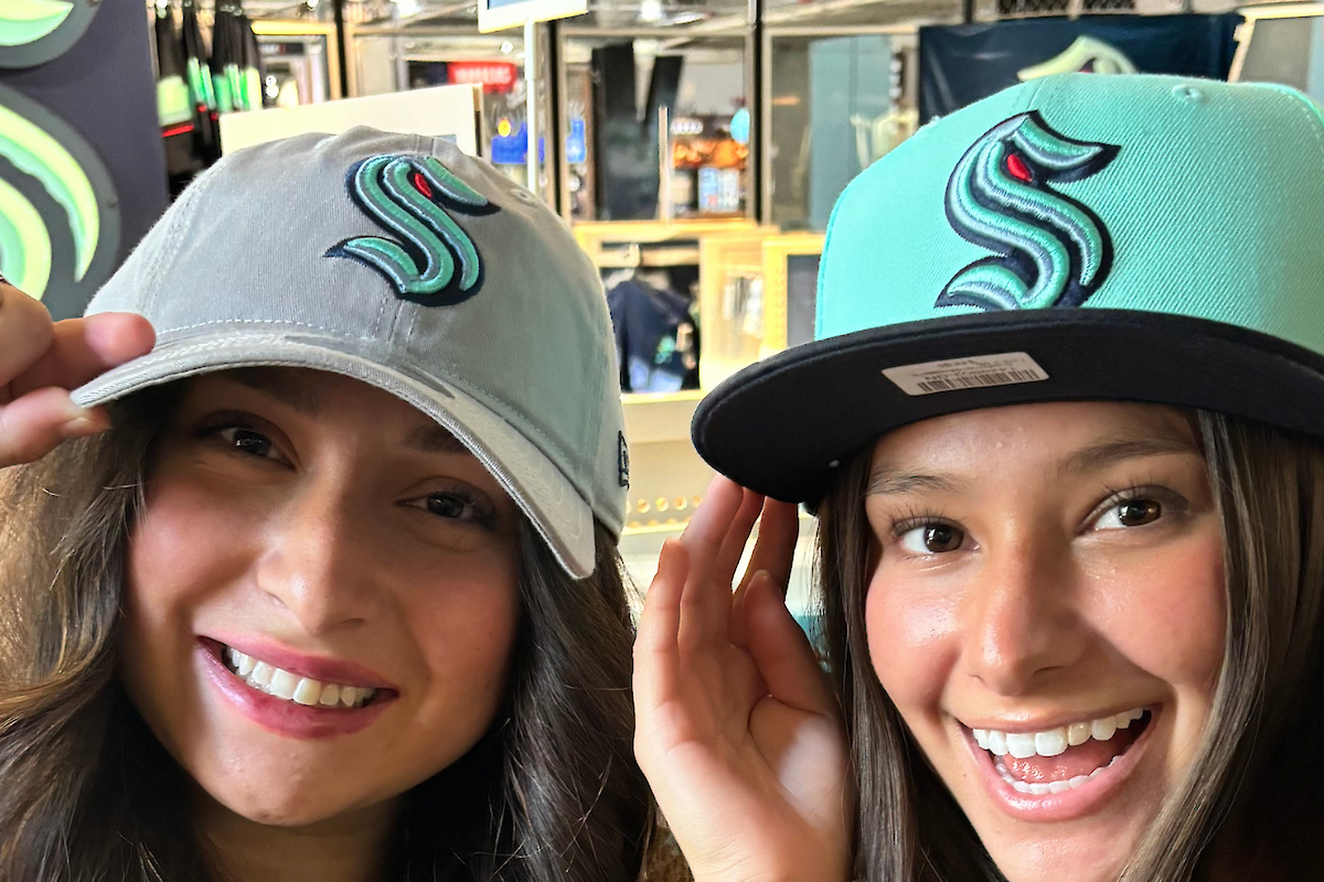 Two people smiling and wearing hats with a stylized 