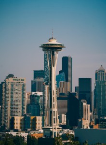 The image shows the Seattle skyline featuring the Space Needle in the foreground with various skyscrapers and buildings in the background.