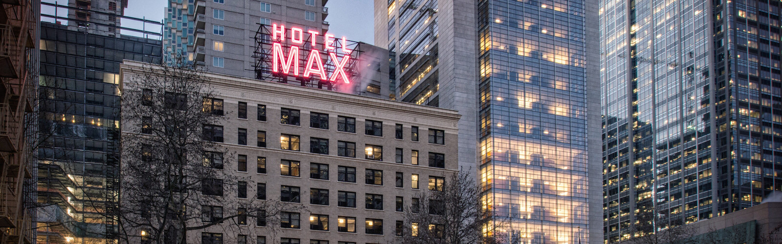The image shows a cityscape at dusk featuring tall buildings, with 