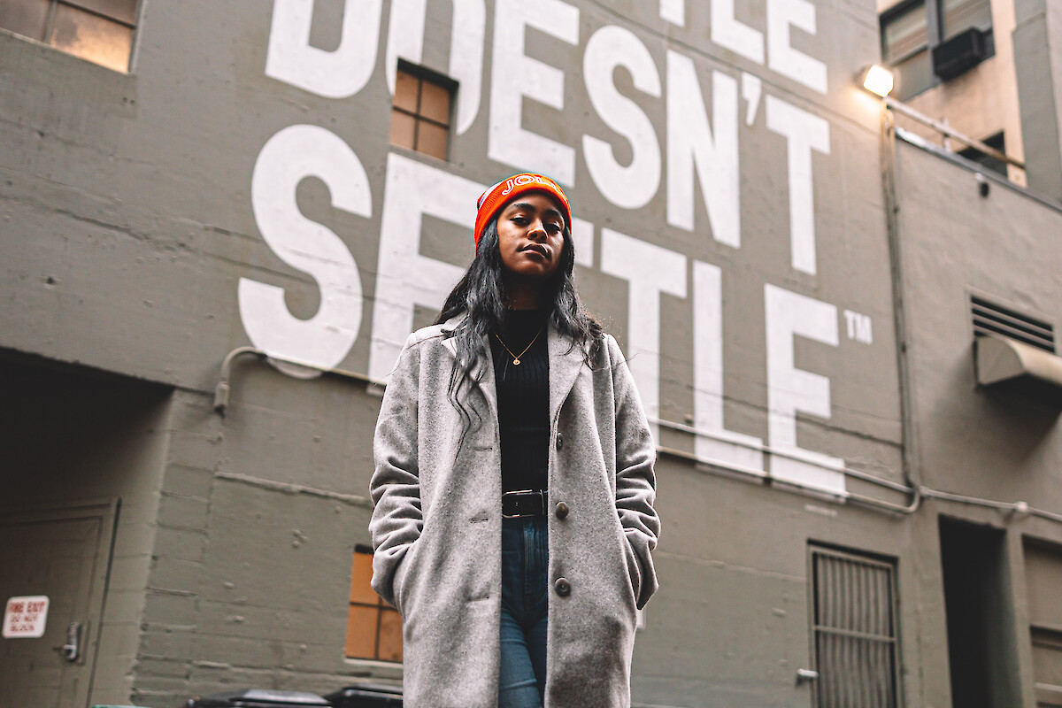 A person stands in front of a wall with 