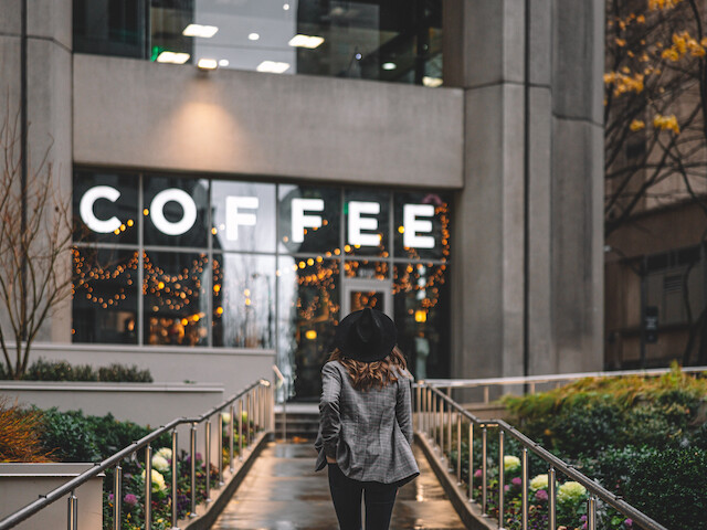 A person walks towards a building with large 