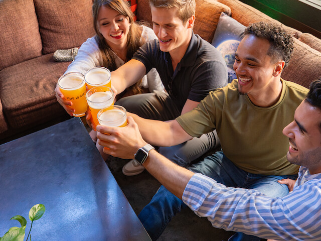 Friends enjoying drinks together in a cozy, well-lit indoor space.