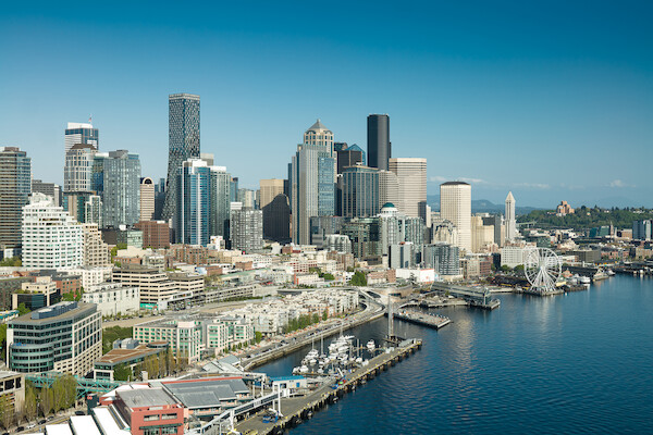 A vibrant city skyline with modern skyscrapers, a waterfront marina, and a large ferris wheel, showcasing urban life and scenic views.